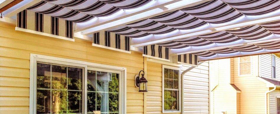 Striped fabric retractable canopies over backyard patio