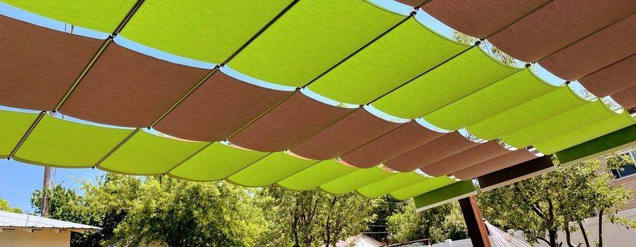 Backyard with shade runner over patio with fabric canopies