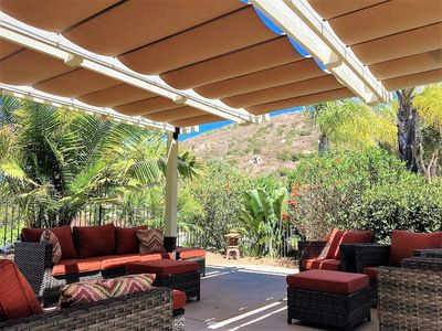 Colorful fabric retractable canopies over backyard patio